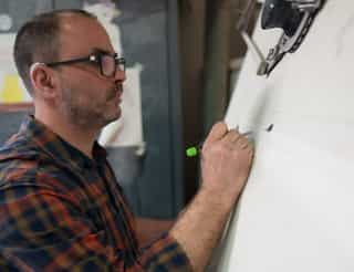 Ein Mitarbeiter schreibt was an ein Whiteboard | Handwerk Leverkusen