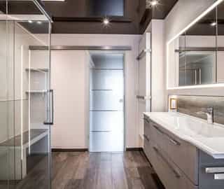 modernes Badezimmer mit Sitzbank und Glastür | Handwerk Leverkusen Sanitär das Qualitätsnetzwerk